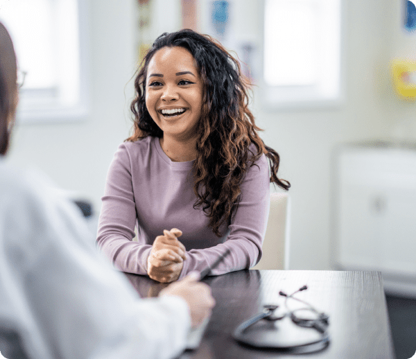 Smiling woman talking to a doctor.