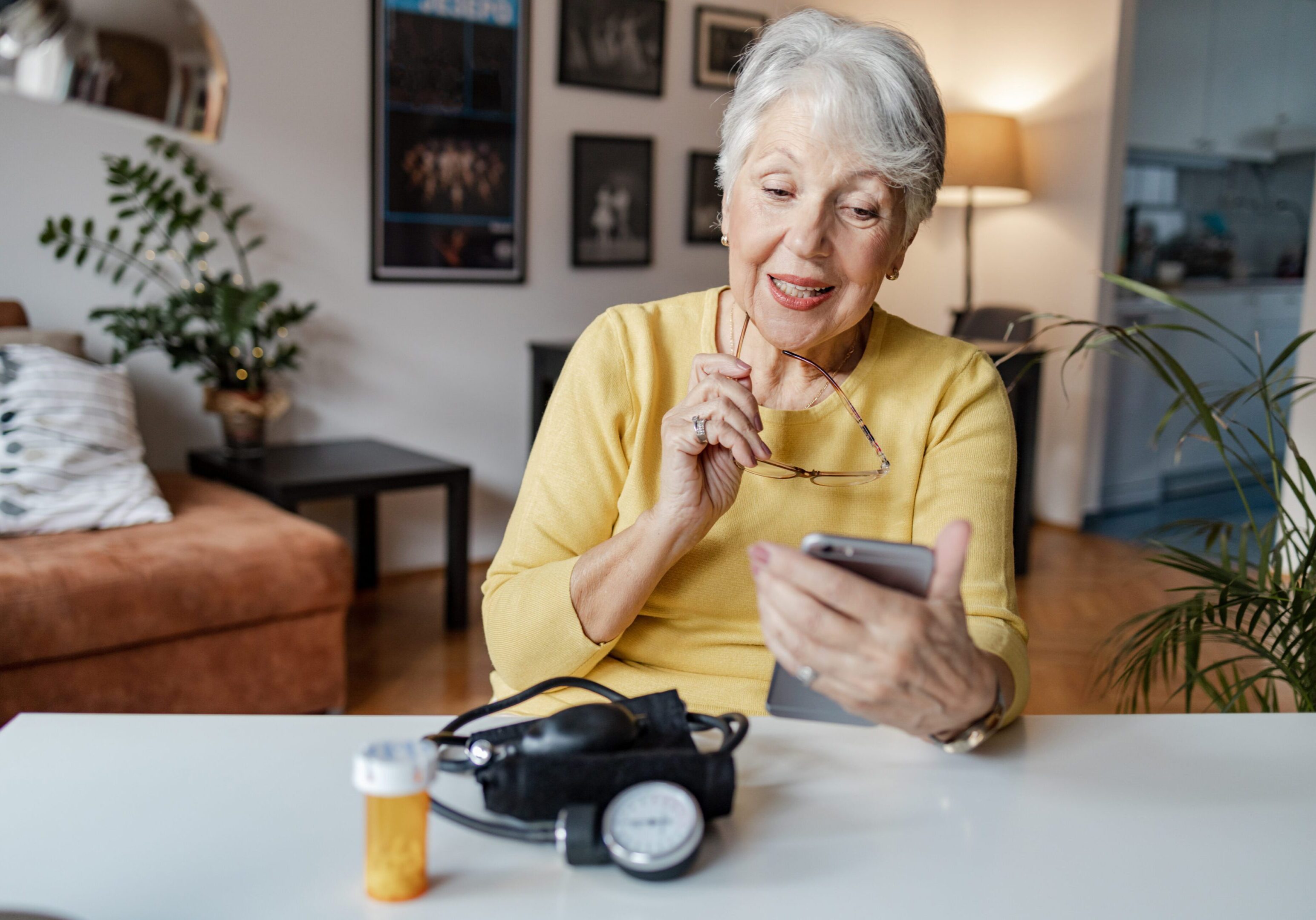 Elderly woman using smartphone at home.